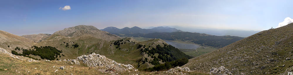 In primo piano, nella metà sinistra della foto panoramica, l'altopiano carsico di Campo dell'Arco che immette nel Vallone Cannella che scende verso il Lago Matese. In secondo piano il mt. Crocetta (1735m) e la Valle dell'Esule davanti alla più alta Gallinola (1923m).  Poi sullo sfondo il mt. Mutria (1823),  il Mt. Porco (1605m) e il Pastonico (1640m). Più in lontananza, al centro della foto,  il Mt. Erbano e Monaco di Gioia e ancora più dietro appena visibile il Pentime-Camposauro.